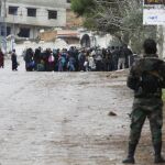 Soldados del ejército sirio vigilan a los residente autorizados a acudir a la zona de espera para recibir la ayuda humanitaria