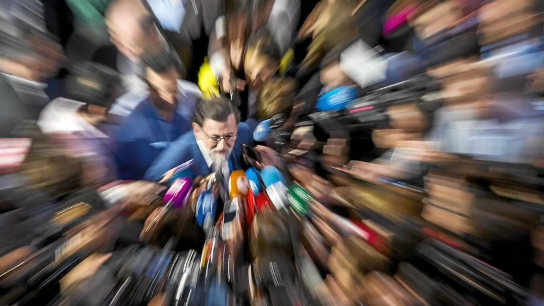 El presidente del Gobierno, Mariano Rajoy, es rodeado por los micrófonos de los periodistas durante la Convención del Partido Popular celebrada en Sevilla, que el partido convocó a principios de abril / Alberto R. Roldán