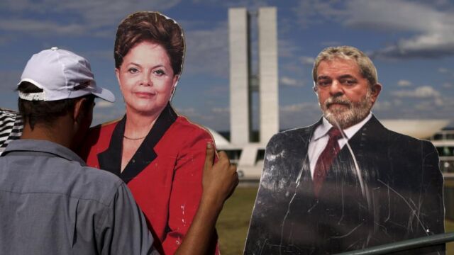 Un manifestante a favor del «impeachment» coloca unas fotografías de Dilma Rousseff y Lula Da Silva , frente al Congreso Nacional en Brasilia