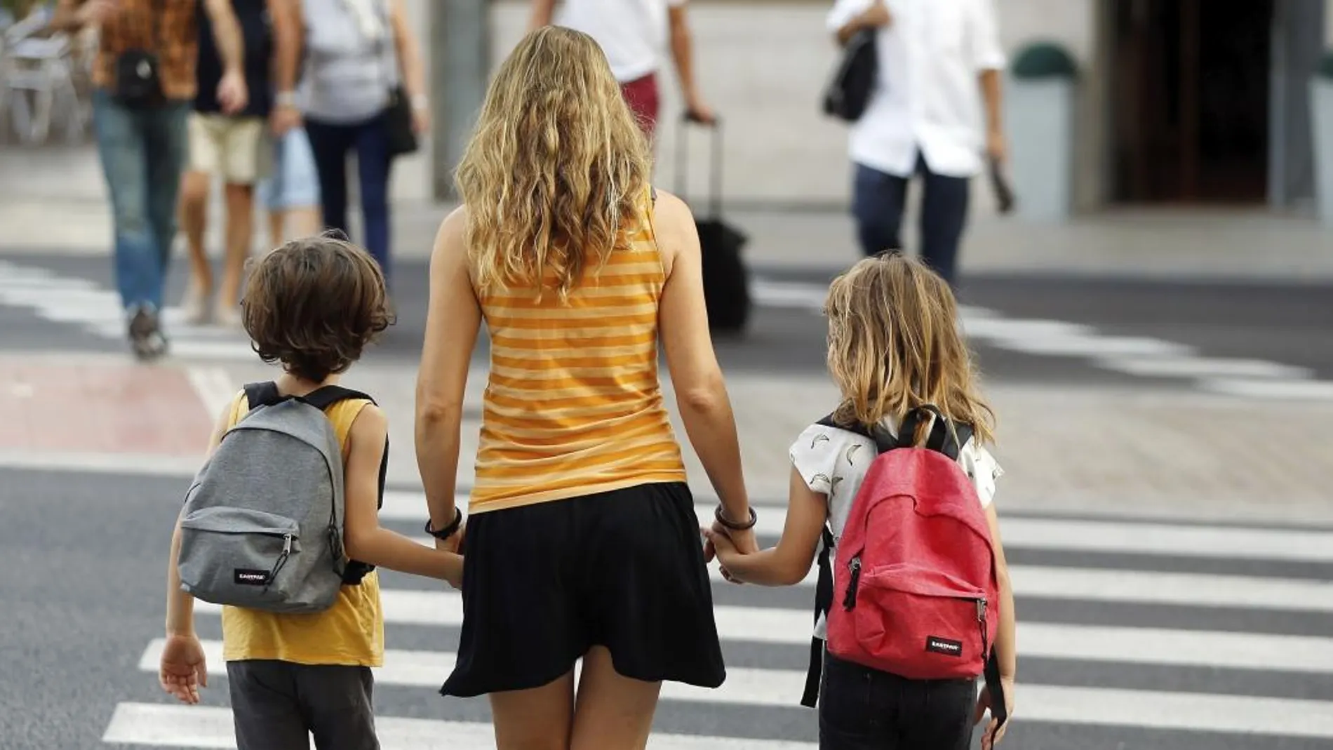 Una madre acompaña esta mañana a sus hijos a la escuela. EFE/Kai Försterling