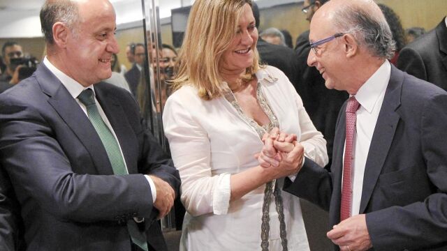 La consejera Pilar del Olmo saluda al ministro Montoro en presencia del director general de Presupuestos y Estadística de la Junta, José Armando Baeta, ayer en Madrid