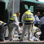 Los servicios de emergenica israelíes trabajan en el lugar del suceso después de que dos personas atacaran un autobús en el barrio de Armon Hanatziv
