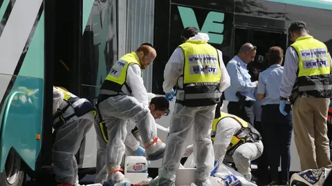 Los servicios de emergenica israelíes trabajan en el lugar del suceso después de que dos personas atacaran un autobús en el barrio de Armon Hanatziv