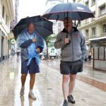 Dos turistas pasean bajo la lluvia en Bilbao