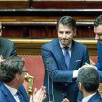 El «premier» Giuseppe Conte, en el centro, rodeado de Luigi di Maio (izqda.) y Matteo Salvini (dcha.), sus dos vicepresidentes, ayer en el Senado