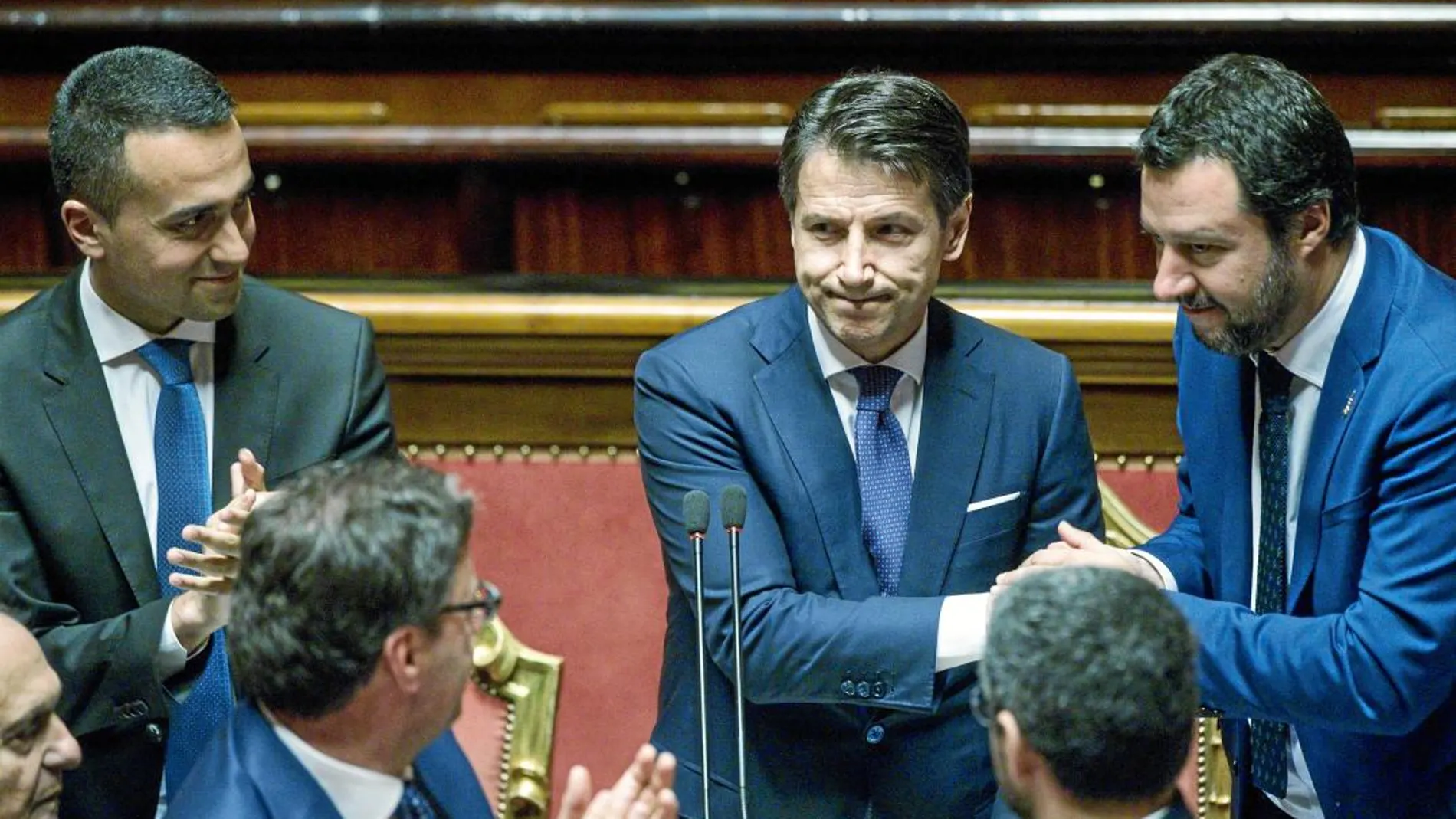 El «premier» Giuseppe Conte, en el centro, rodeado de Luigi di Maio (izqda.) y Matteo Salvini (dcha.), sus dos vicepresidentes, ayer en el Senado