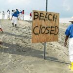 Un grupo de voluntarios limpia de petróleo la playa Grand Isle (Luisiana), que ha sido cerrado a consecuencia del vertido