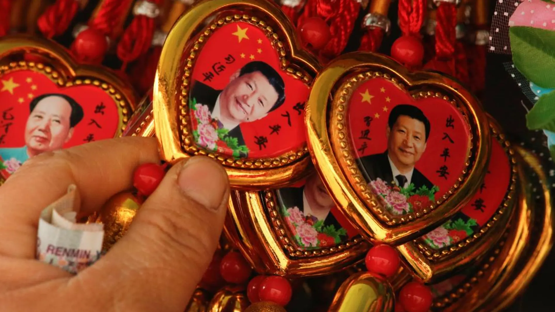 Souvenirs con el retrato del presidente Xi Jinping junto a otros que incluyen imágenes de Mao Zedong en la plaza de Tiananmen, en Pekín, China,