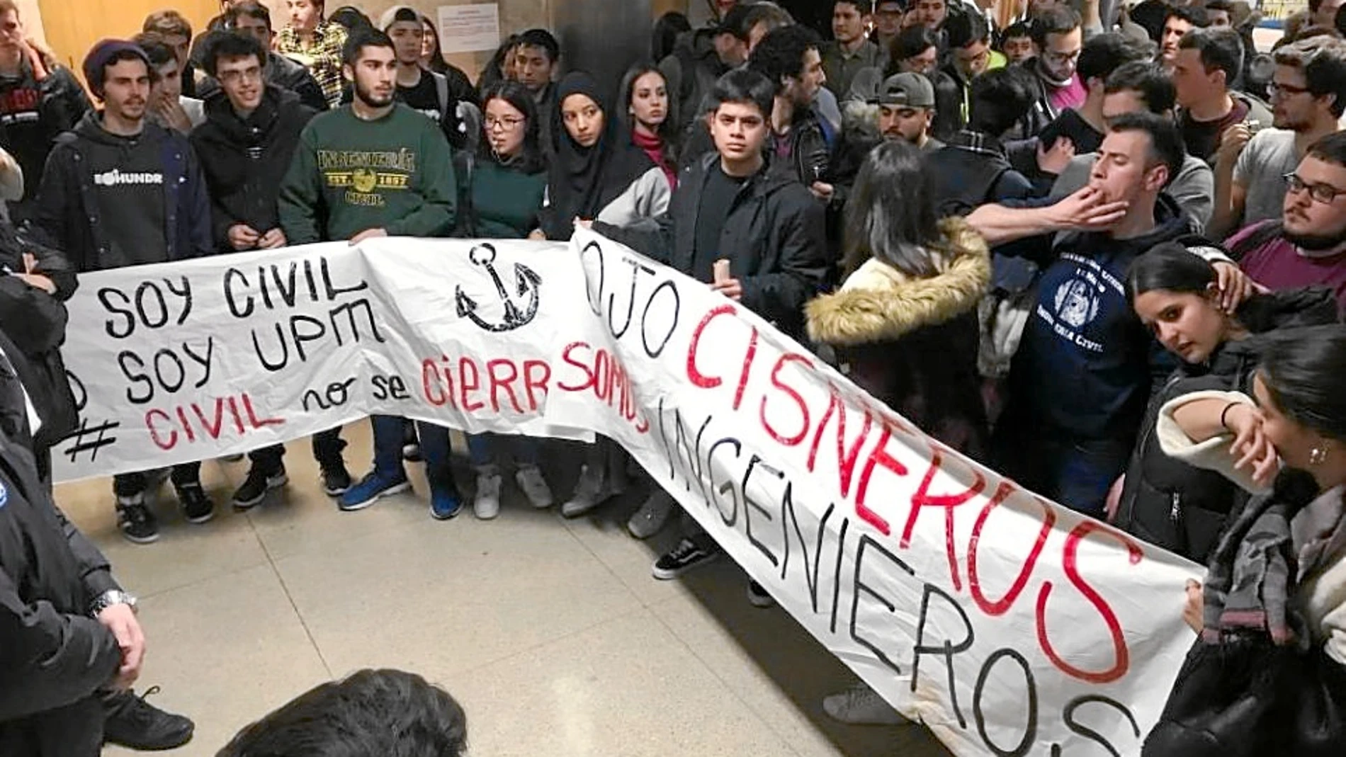 Un grupo de estudiantes sujeta una pancarta en contra del rector de la UPM, Guillermo Cisneros