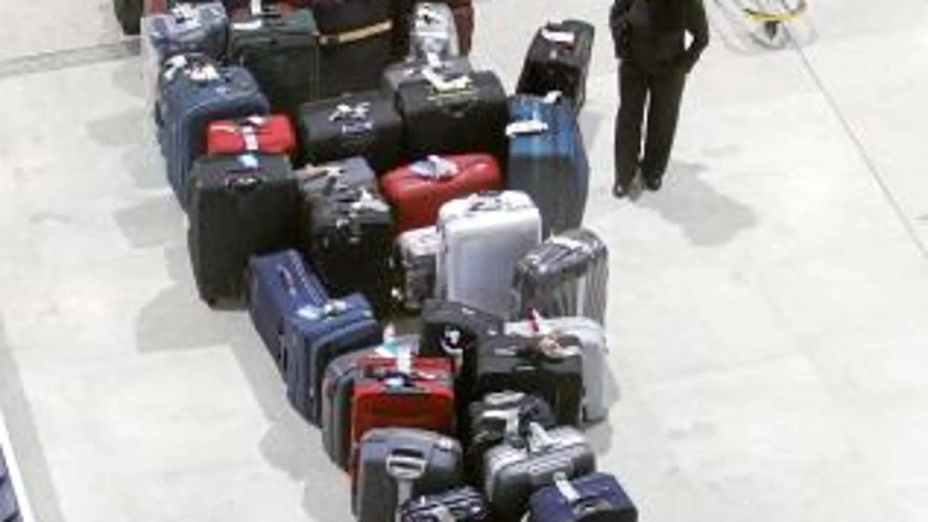 Cientos de maletas se amontonaban ayer en las cintas de Barajas