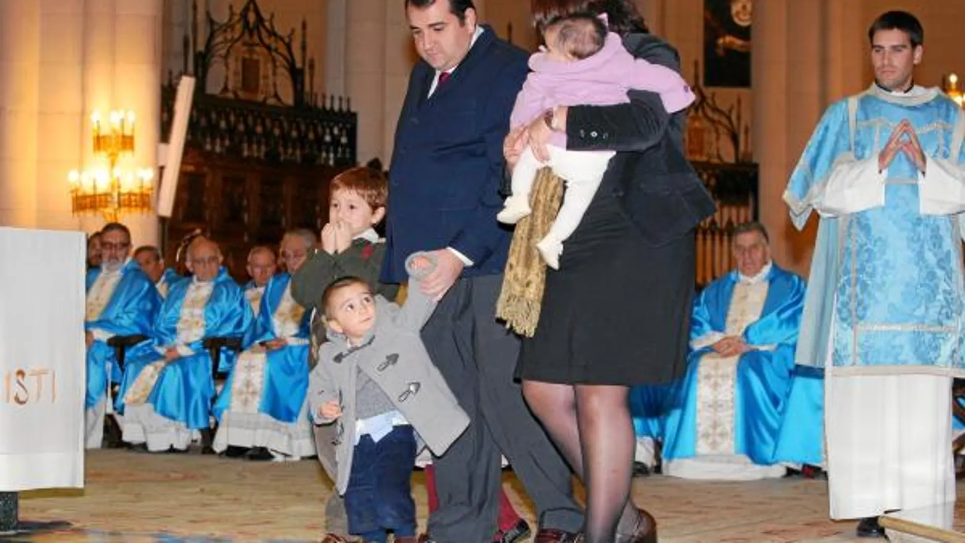 Una familia participa en las ofrendas de la vigilia del año pasado, bajo la mirada de sacerdotes y un diácono revestidos de azul, color excepcional en honor a la Inmaculada Concepción