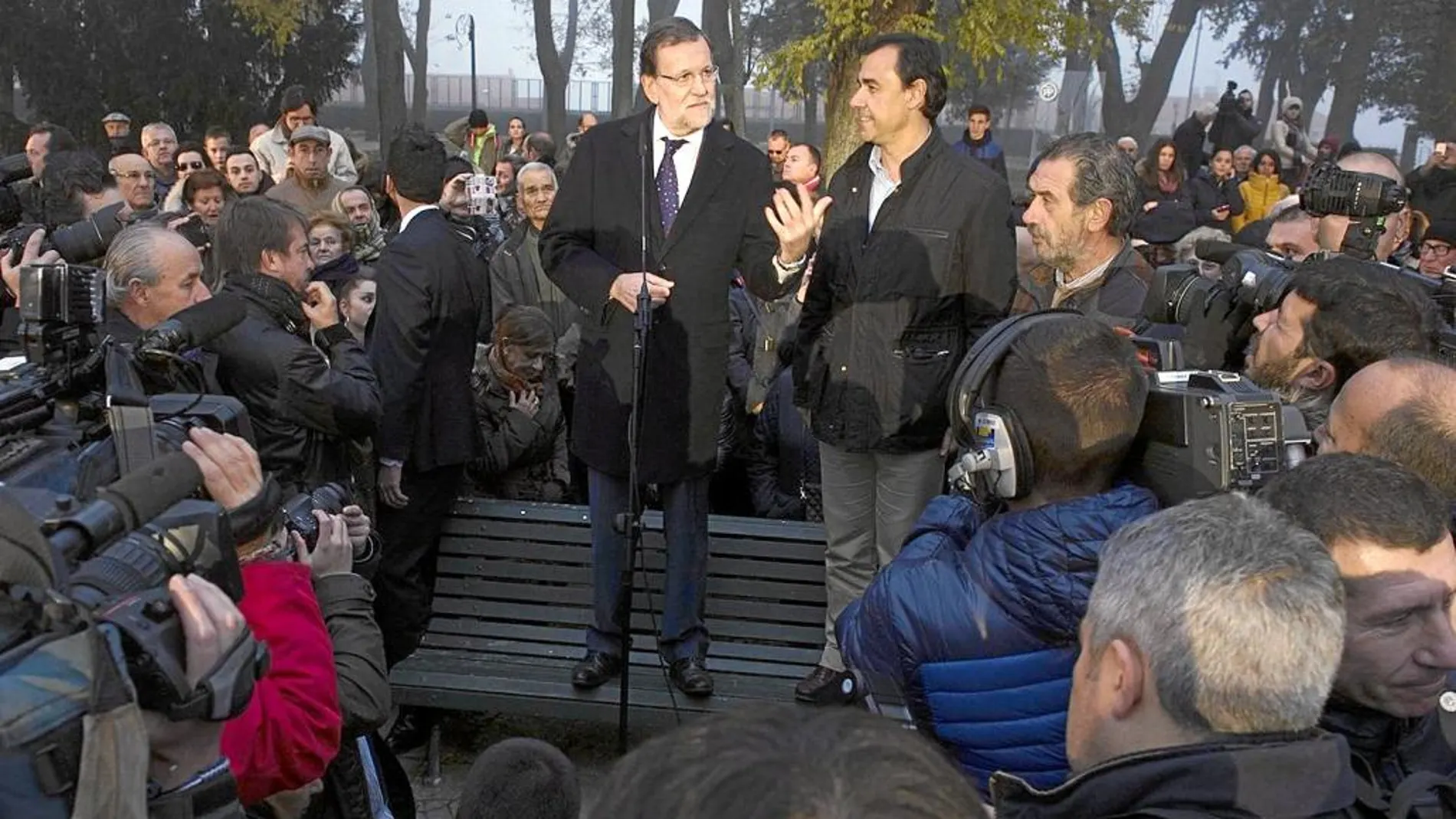 Rajoy se dirige a los vecinos de Benavente subido en un banco de los Jardines de la Mota de la localidad