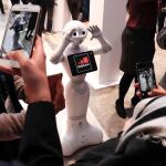 Visitantes fotografían a Pepper, el robot humanoide de la compañía japonesa SoftBank Robotic
