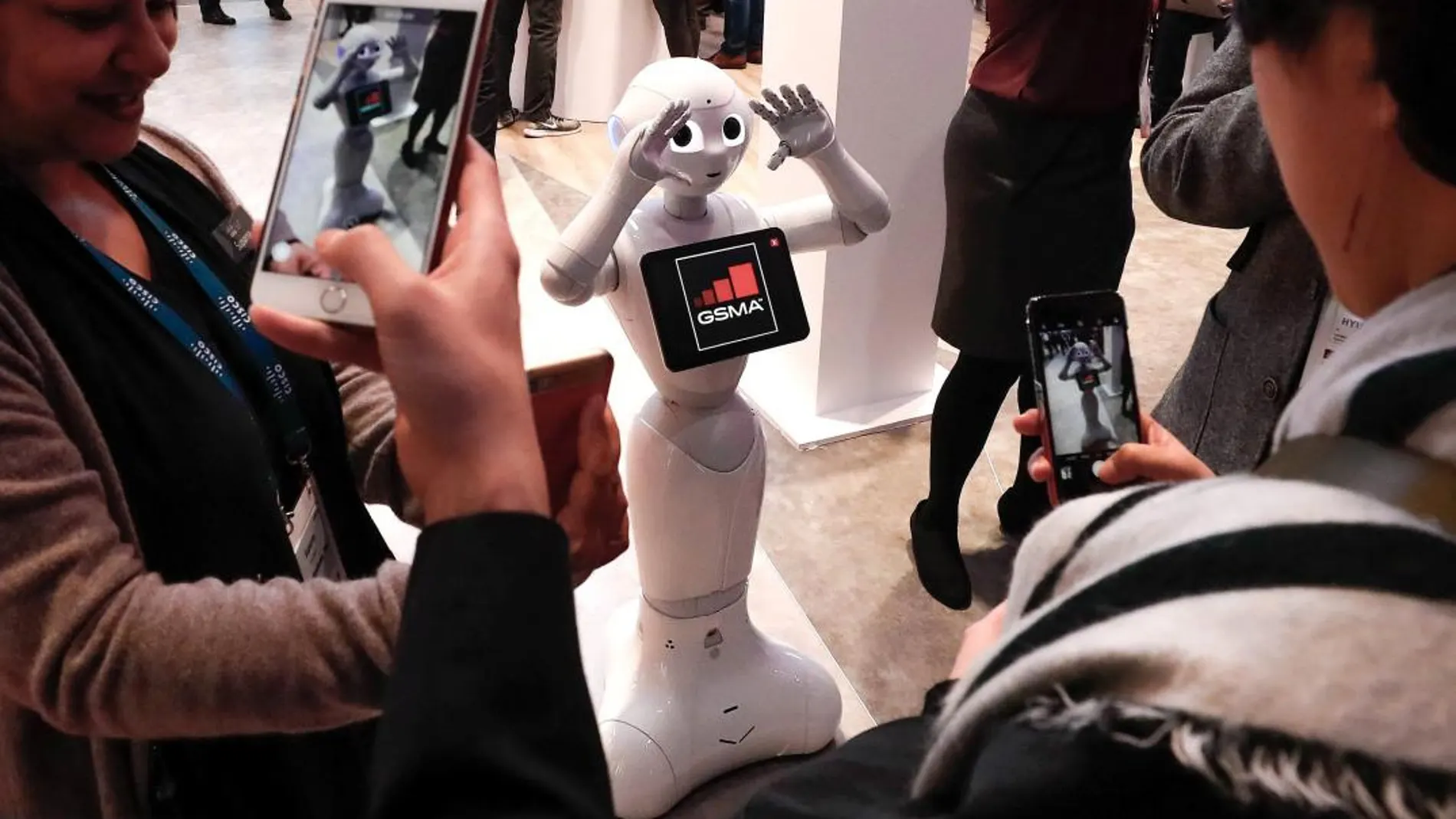 Visitantes fotografían a Pepper, el robot humanoide de la compañía japonesa SoftBank Robotic