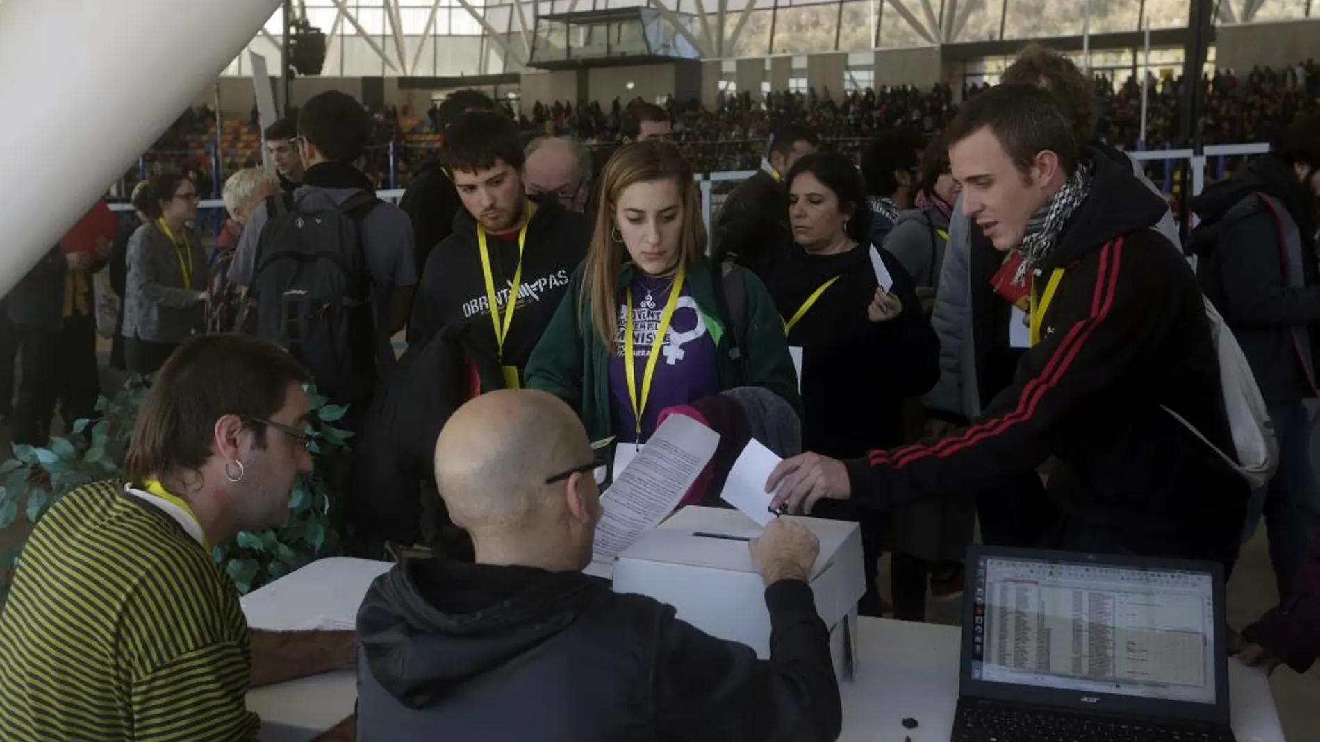 Participantes en la primera votación realizada durante la asamblea de la CUP sobre la investidura de Artur Mas como presidente de la Generalitat, tras más de tres horas de intenso y disputado debate