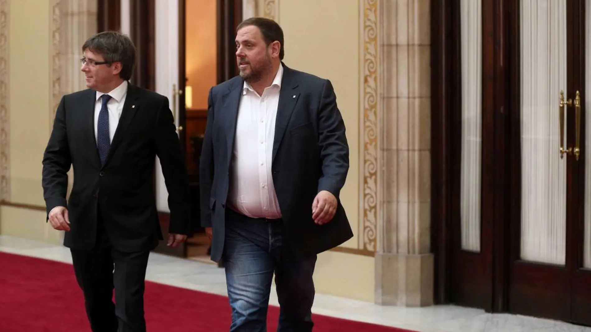 Carles Puigdemont y Oriol Junqueras salen del despacho de presidencial en el Parlament tras la reunión que han mantenido con los diputados de la CUP, Anna Gabriel y Joan Garriga