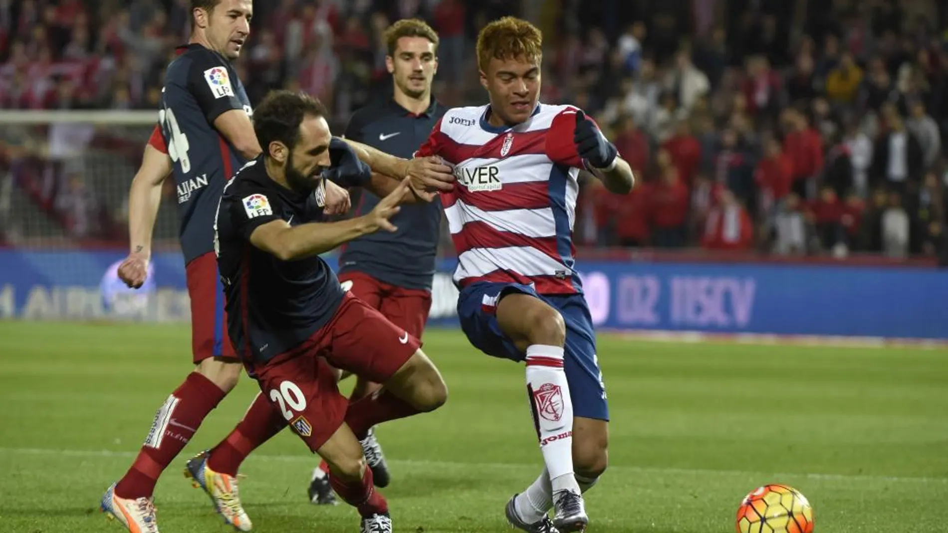 El defensa del Atlético de Madrid Juanfran Torres pelea un balón con el delantero venezolano del Granada Adalberto Peñaranda