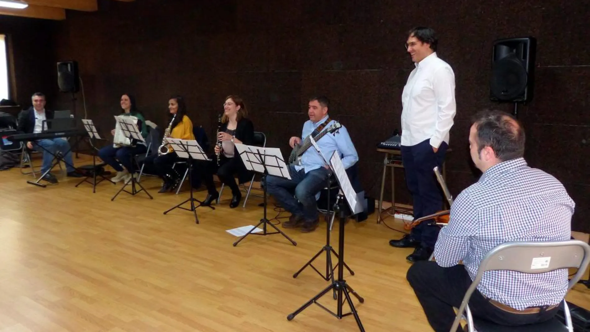El director de la Escuela de Música, Aitor Olivares, junto con algunos de los alumnos que interpretan una pieza