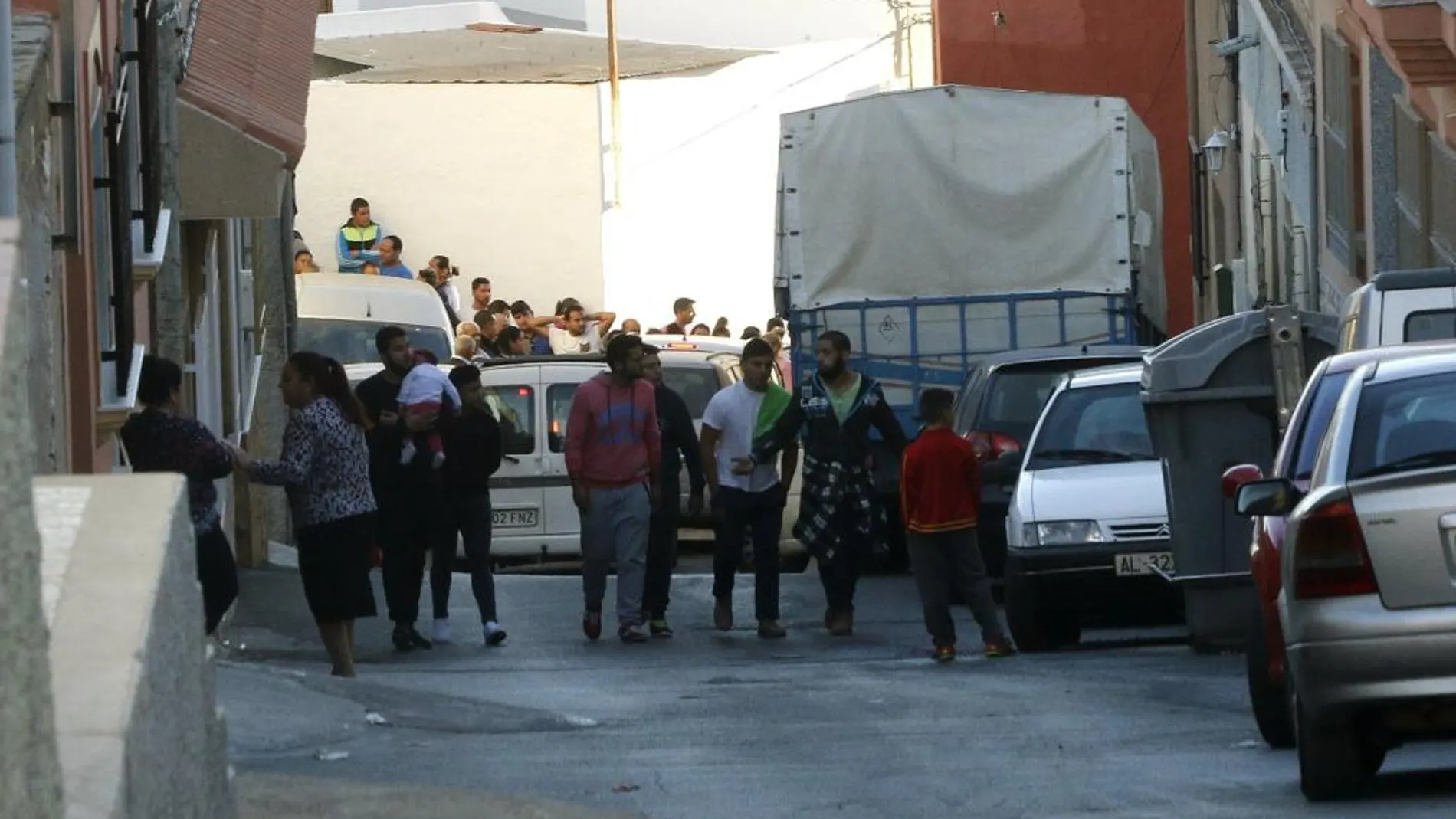 Un grupo de vecinos se agolpan frente a la vivienda en la localidad almeriense de Adra, donde la Guardia Civil ha localizado los cadáveres de un hombre de 62 años y de una mujer marroquí de 23
