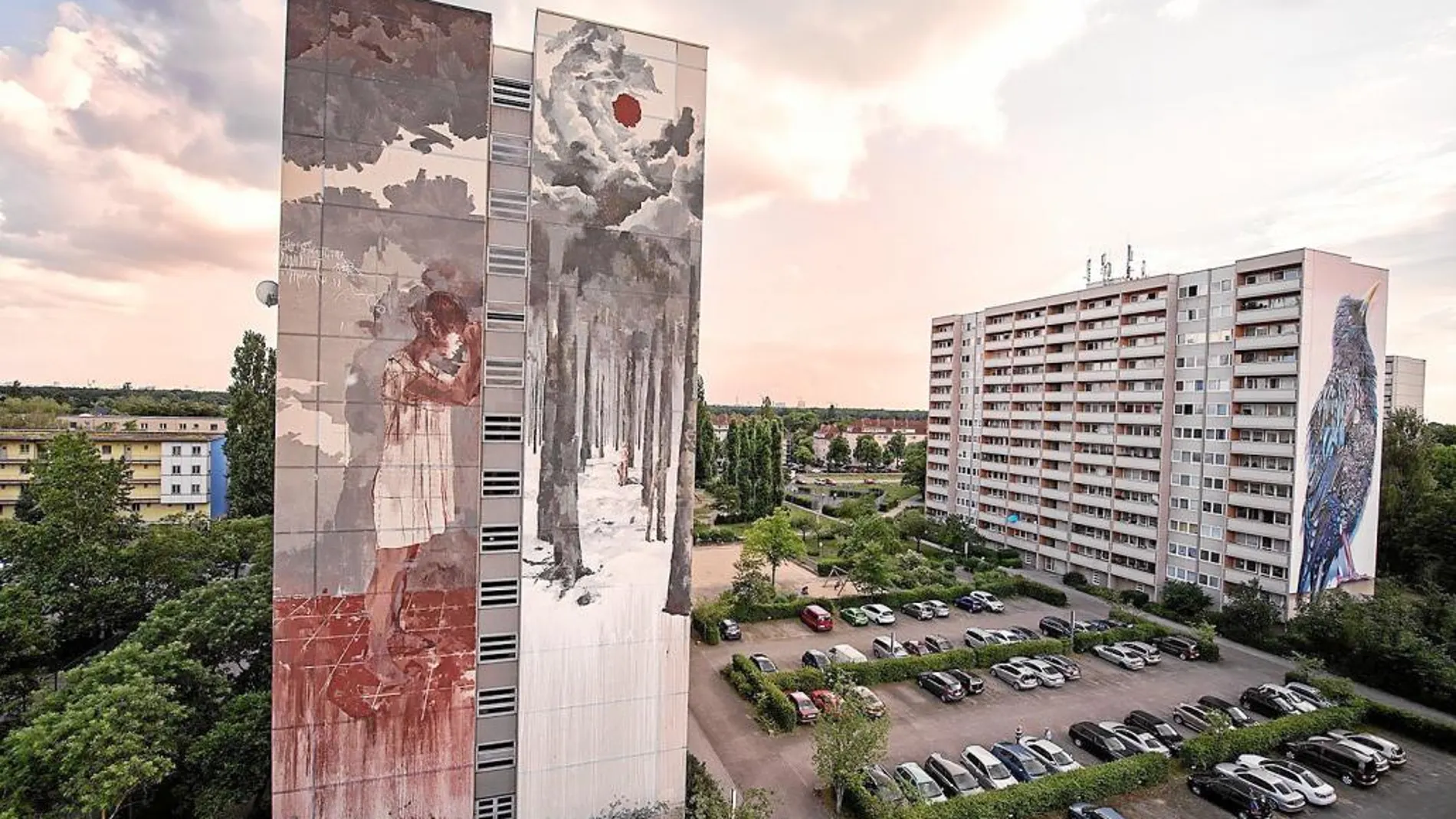 La obra de la polémica ocupa los 42 metros de una fachada. Junto a ella, un pájaro azul, obra en las antípodas de la de Borondo