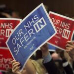 Seguidores del líder laborista, Jeremy Corbyn (no aparece en la imagen), sostienen pancartas de apoyo durante su discurso sobre el sistema nacional de salud y el referéndum sobre la permanencia del Reino Unido en la Unión Europea
