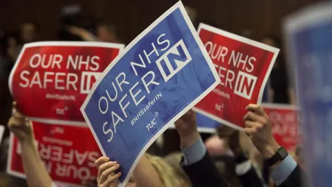 Seguidores del líder laborista, Jeremy Corbyn (no aparece en la imagen), sostienen pancartas de apoyo durante su discurso sobre el sistema nacional de salud y el referéndum sobre la permanencia del Reino Unido en la Unión Europea