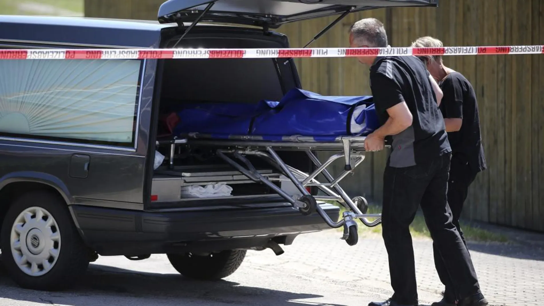 Empleados de una funeraria trasladan un cadáver desde la zona donde se ha producido un tiroteo en Ansbach, en el sur de Alemania.