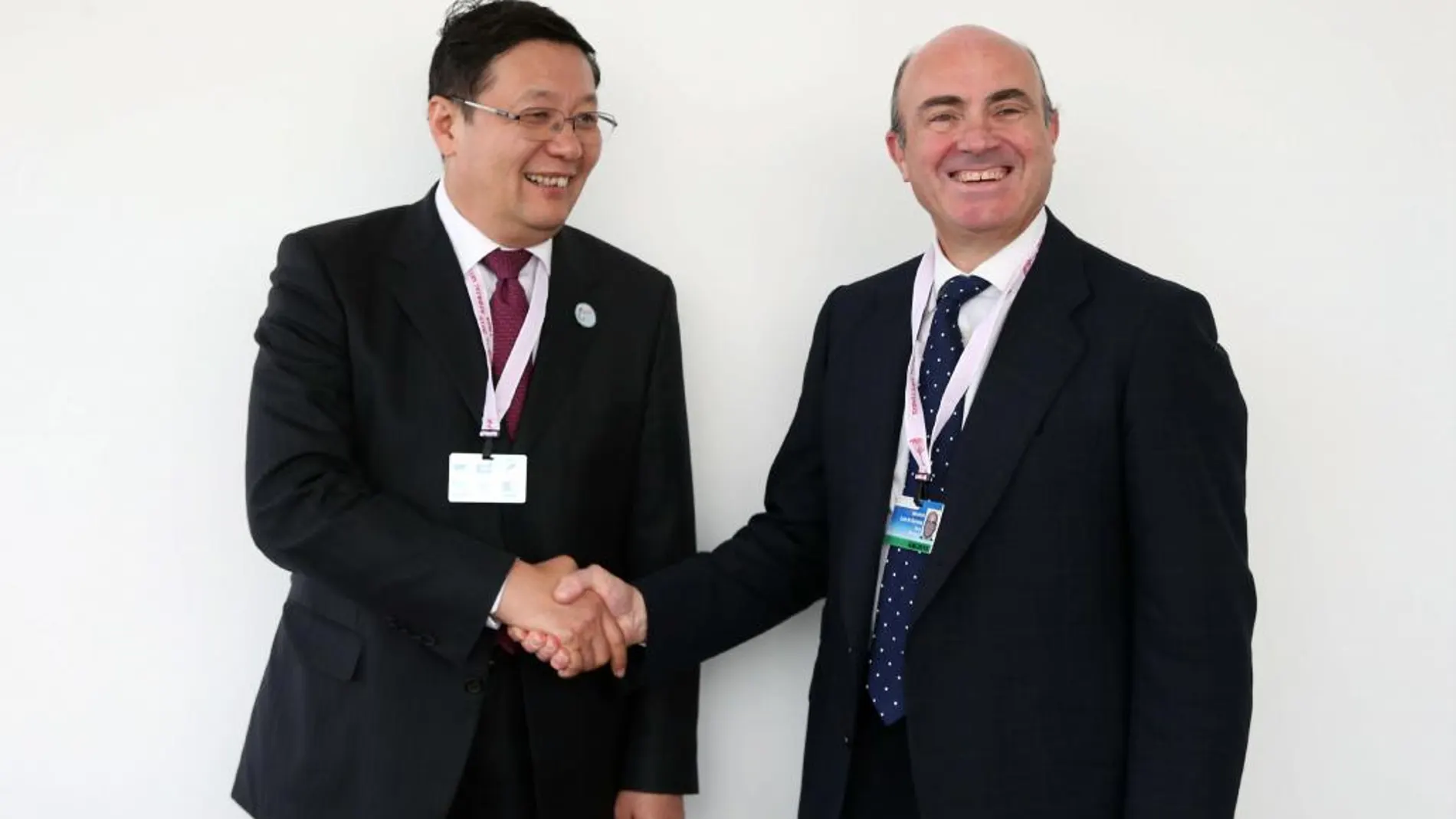 El ministro de Finanzas chino, Lou Jiwei (i) da la mano al ministro de Economía de España, Luis de Guindos (d)