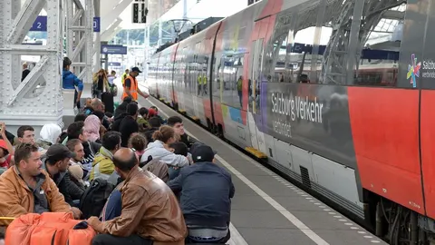 Refugiados esperan para tomar un tren con dirección a Alemania en la estación de Salzburgo