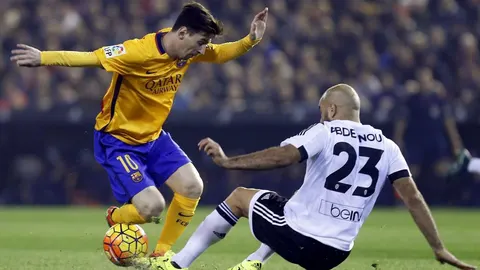 El defensa tunecino del Valencia, Aymen Abdennour, pelea un balón con el delantero argento del Barcelona, Lionel Messi