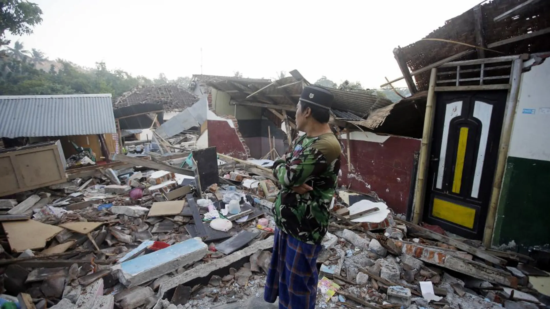 Un hombre inspecciona su casa destrozada por el terremoto del pasado domingo en Lombok / Foto: Ap