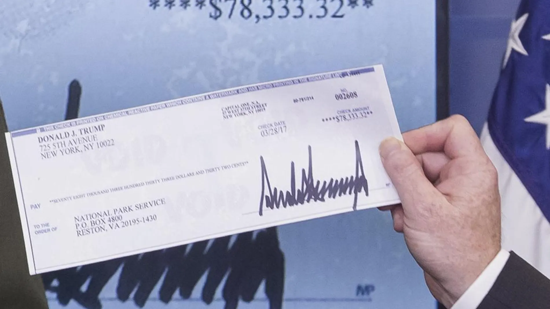 El secretario de Prensa de la Casa Blanca, Sean Spicer, sostiene un cheque donado por el presidente de Estados Unidos, Donald Trump