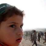 . Un niño palestino mira hacia el antiguo asentamiento de Neve Dekalim, en la franja de Gaza, en una foto de archivo/Efe