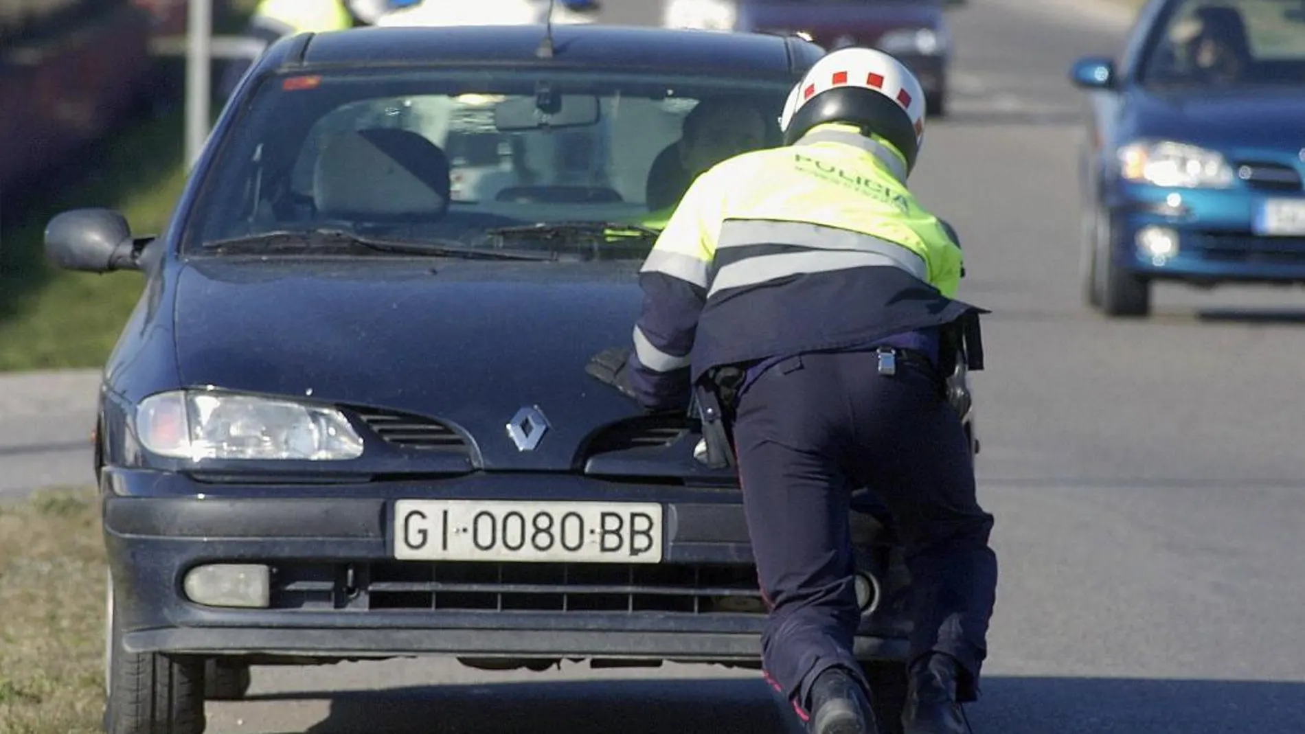 Un Mosso d'Esquadra aparta un vehículo averiado en la N-260, en Castelló d'Empuries (Gerona)