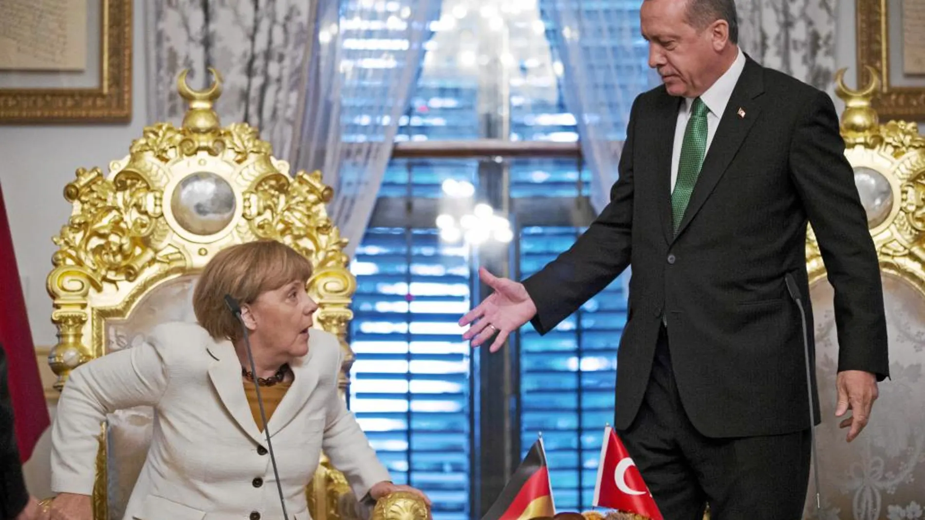 El presidente turco, Tayip Erdogan, ofrece su mano a Merkel después de su encuentro en Estambul