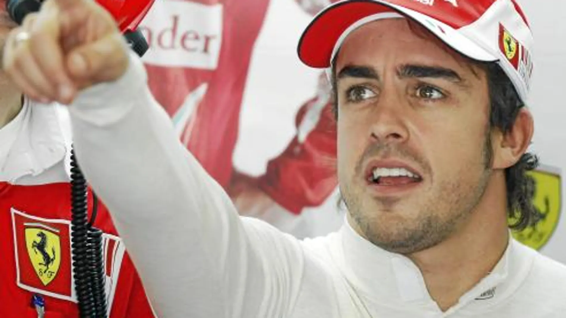 Fernando Alonso señala una de las pantallas en el box de Ferrari durante la primera sesión de entrenamientos