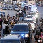 Un convoy con decenas de sirios evacuados a su paso por la frontera libanesa, ayer