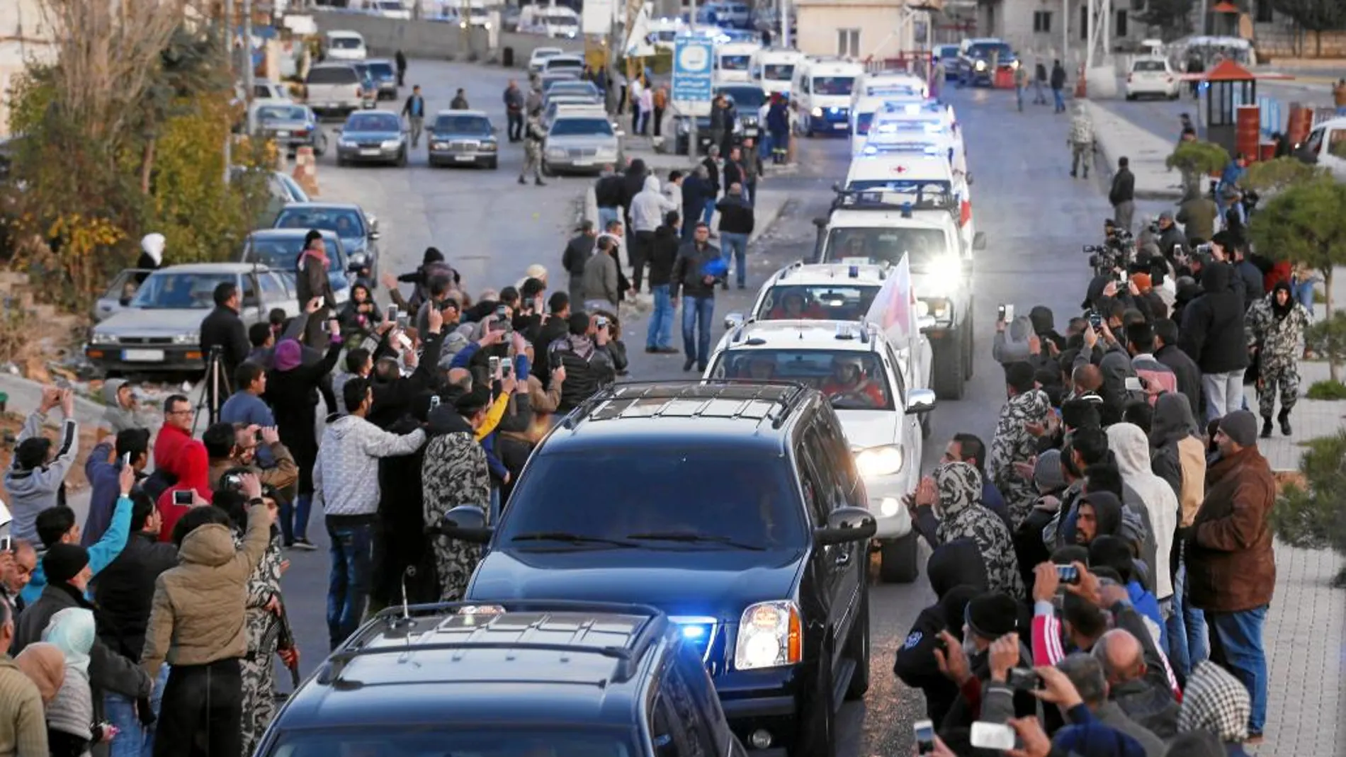 Un convoy con decenas de sirios evacuados a su paso por la frontera libanesa, ayer