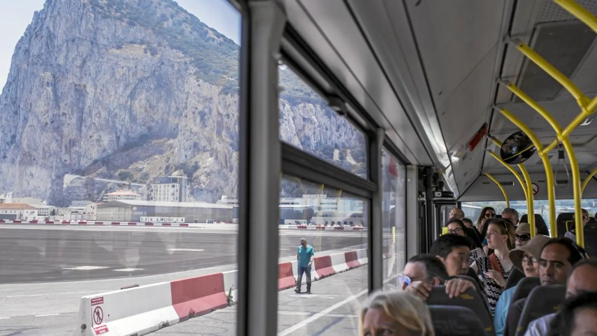 Varios viajeros observan el Peñón desde el autobús a su llegada al aeropuerto de Gibraltar el día después del referéndum
