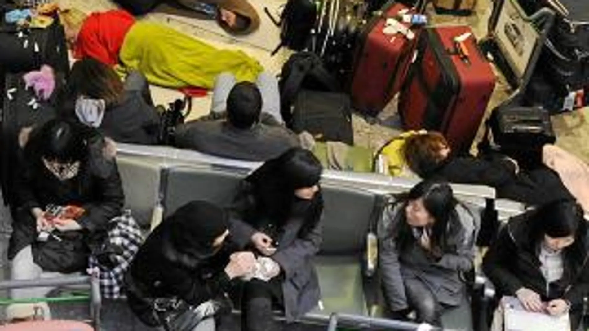 Miles de pasajeros esperan con su equipaje en la terminal 3 del aeropuerto londinense de Heathrow, el más afectado por el temporal