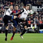 Los jugadores del Valencia CF, Santi Mina (i) y el argentino Luciano Vietto (d), disputa un balón con el jugador del Levante UD, Roberto Suárez
