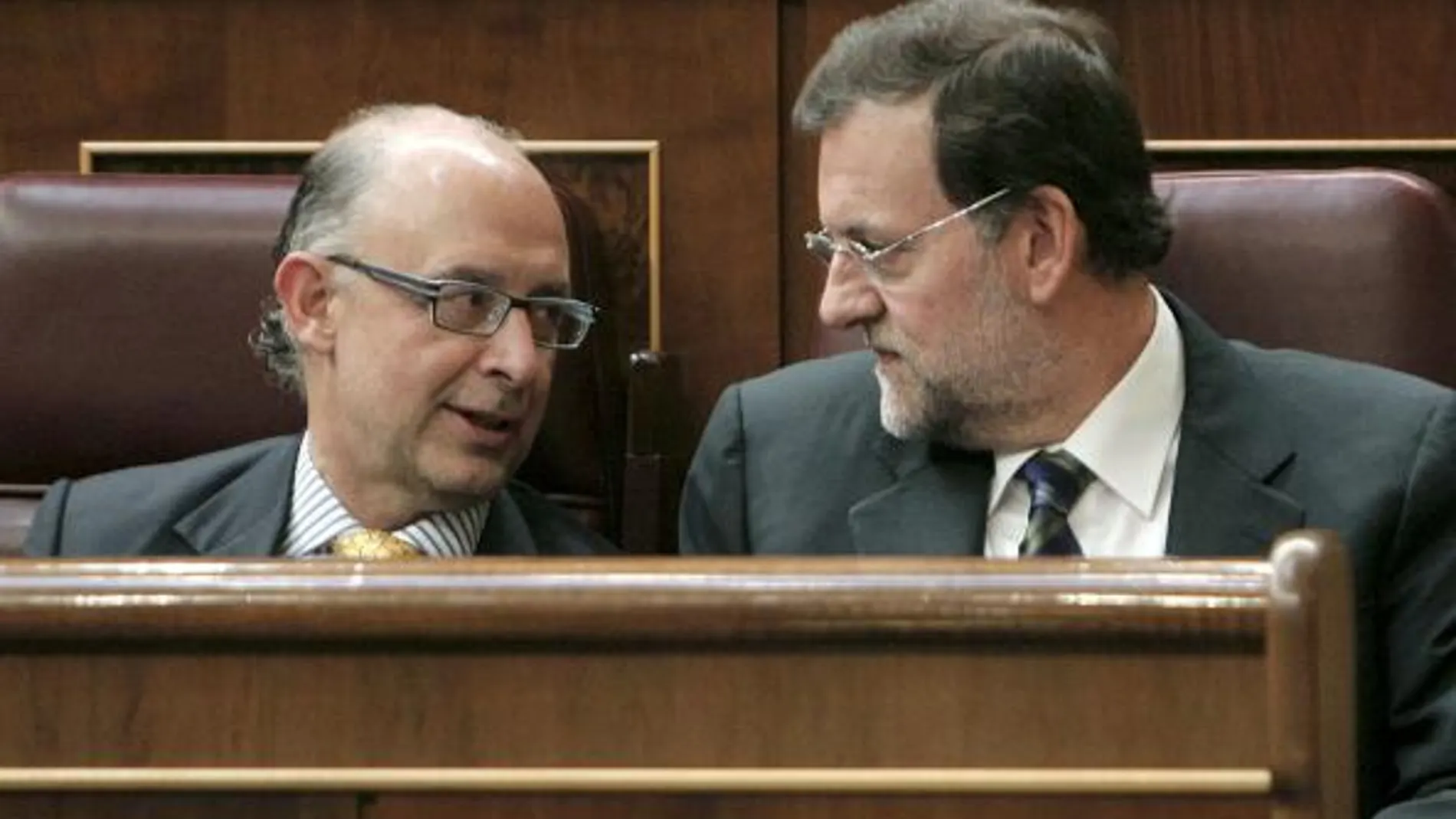 Mariano Rajoy (d), conversa con el portavoz de Economía del PP en el Congreso, Cristóbal Montoro (i)