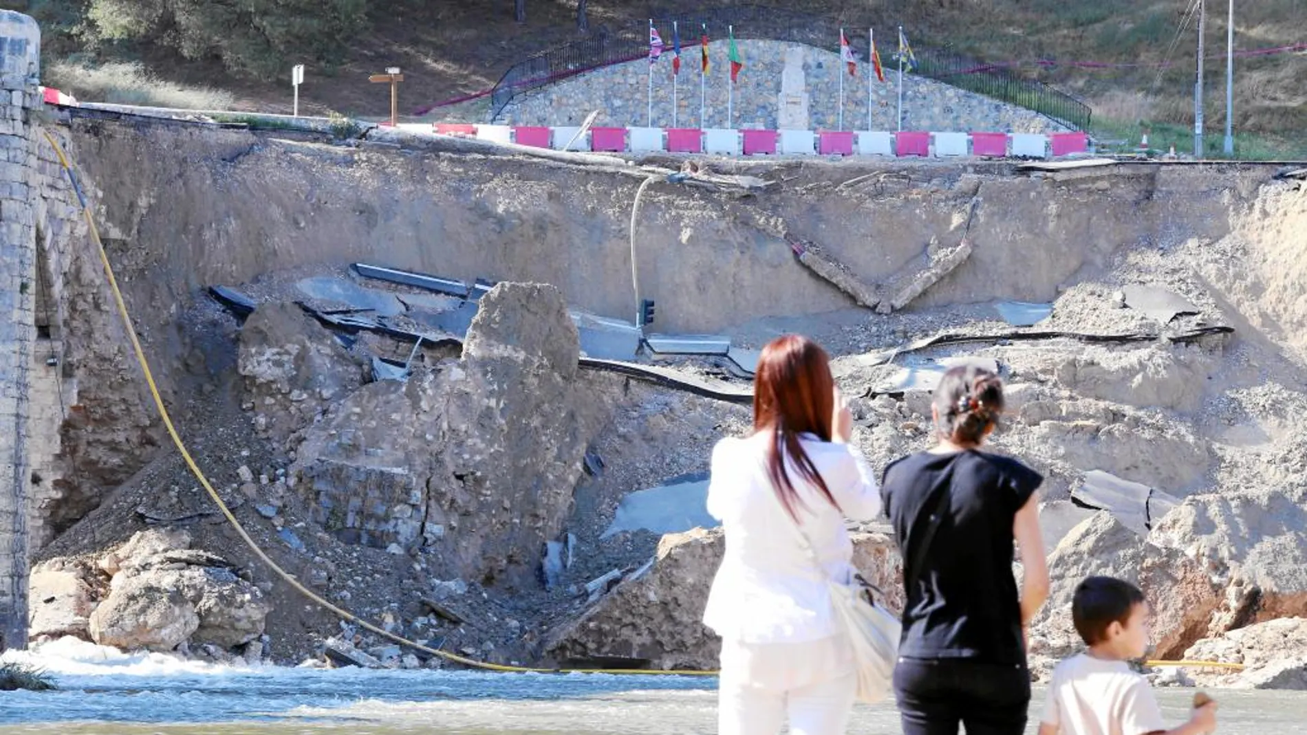 Dos mujeres y un niño, vecinos de Cabezón, observan el estado del puente tras el derrumbe