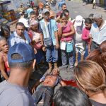 Vecinos de San Félix hacen un corro ante el cadáver de Gustavo Patiñis, en el estado de Bolívar