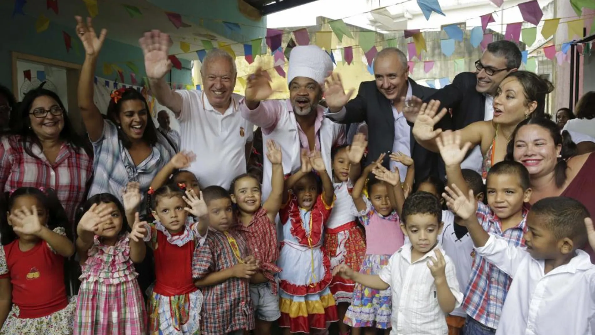 García-Margallo y Carlinhos Brown, rodeados de niños y maestros durante su visita al colegio infantil del barrio de Candeal