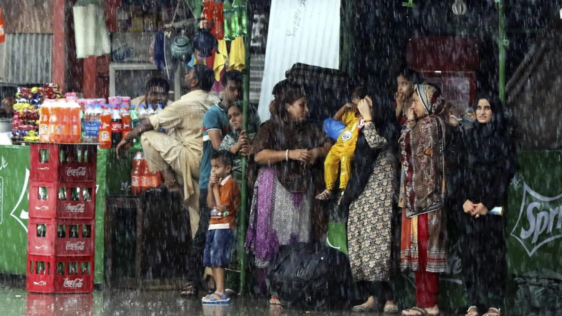 Varias personas se protegen de la lluvia en Lahore, Pakistán
