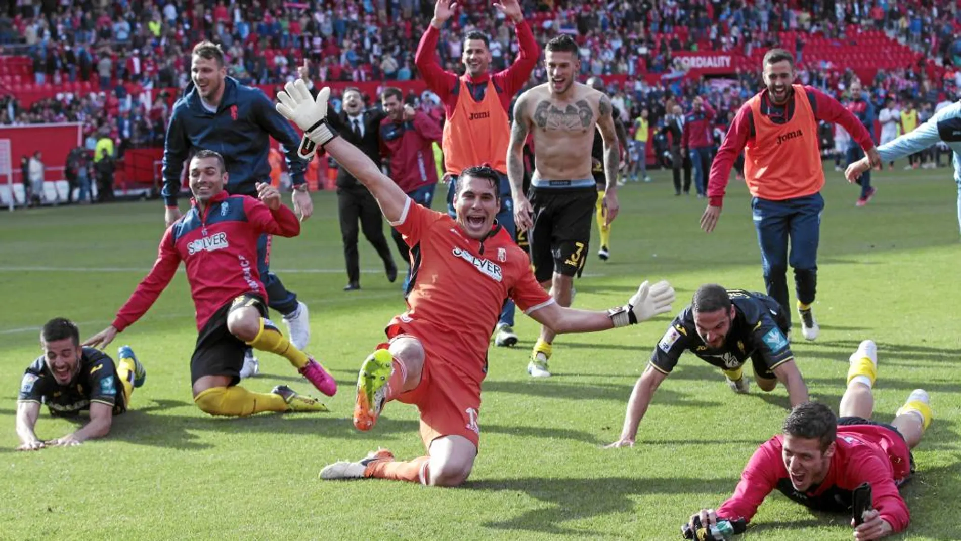 Los jugadores del Granada celebran la permanencia que consiguieron al golear en el Sánchez Pizjuán