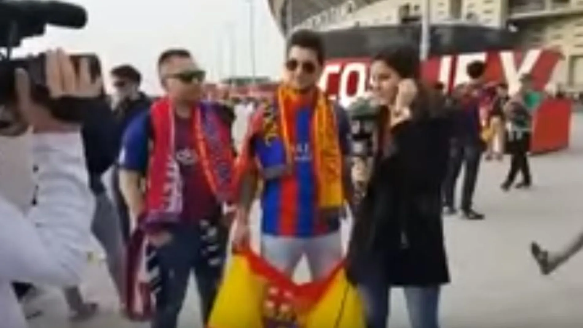 Imagen de los aficionados, todavía con la bandera de España, junto a la reportera de Barça TV