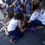 Varias personas tratan de ayudar a una de las seis personas apuñaladas mientras participaban en la Marcha del Orgullo Gay en Jerusalén