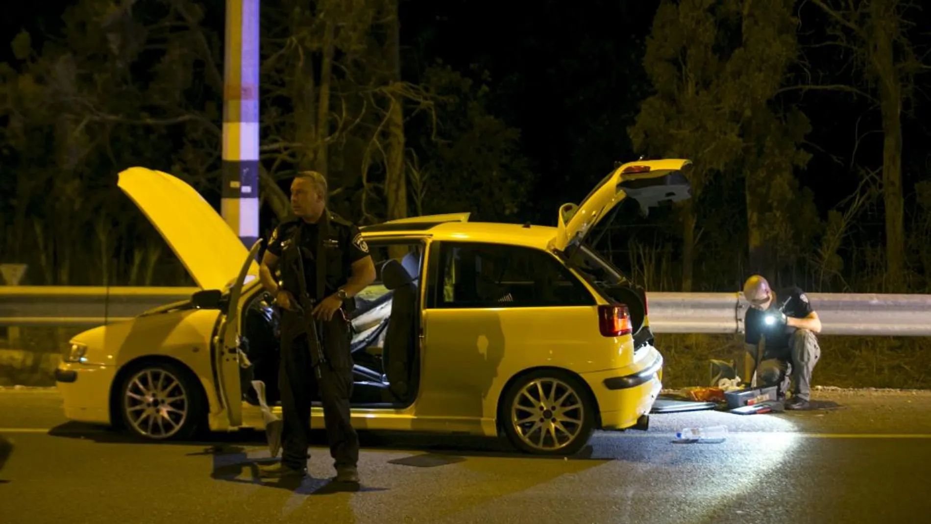 Policías israelíes junto al coche utilizado por un ciudadano árabe de Israel para atacar y herir a cuatro ciudadanos israelíes en Gan Shmuelt, Hadera